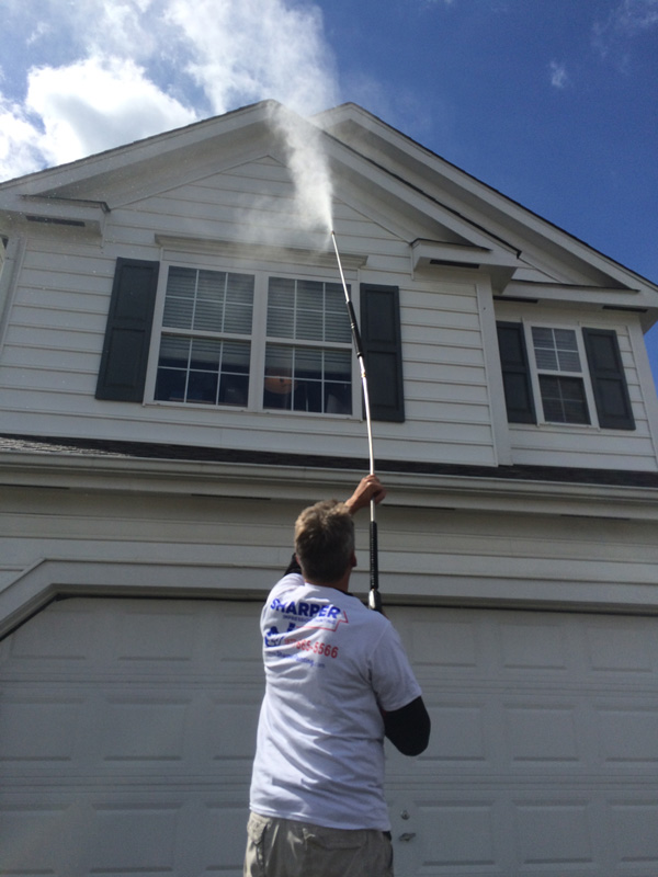 Professional Power Washing a House Before Painting